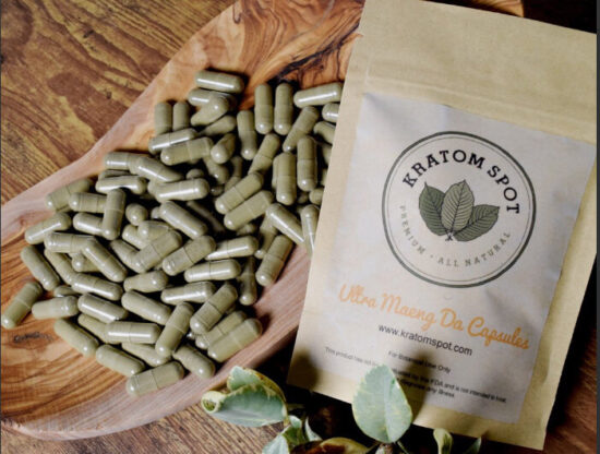 A pouch of Kratom capsules next to a bowl filled with Kratom capsules