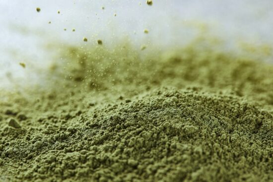 A pile of fresh kratom on a marble surface