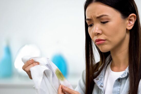 A woman stares at a white shirt with kratom stains
