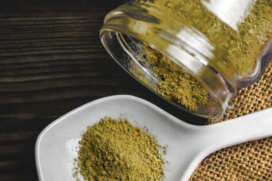 A dose of kratom sits measured out, ready for use in an oblate disc