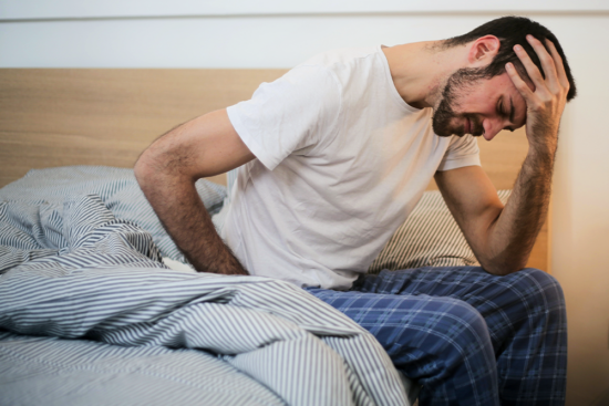 A man hunched over, suffering from a killer kratom hangover