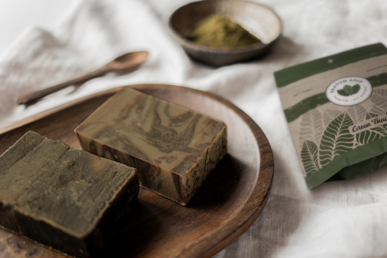 Two bars of kratom soap in a wooden bowl