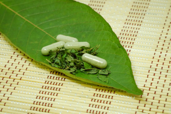 super, ultra, and standard indo kratom powder and capsules on a leaf